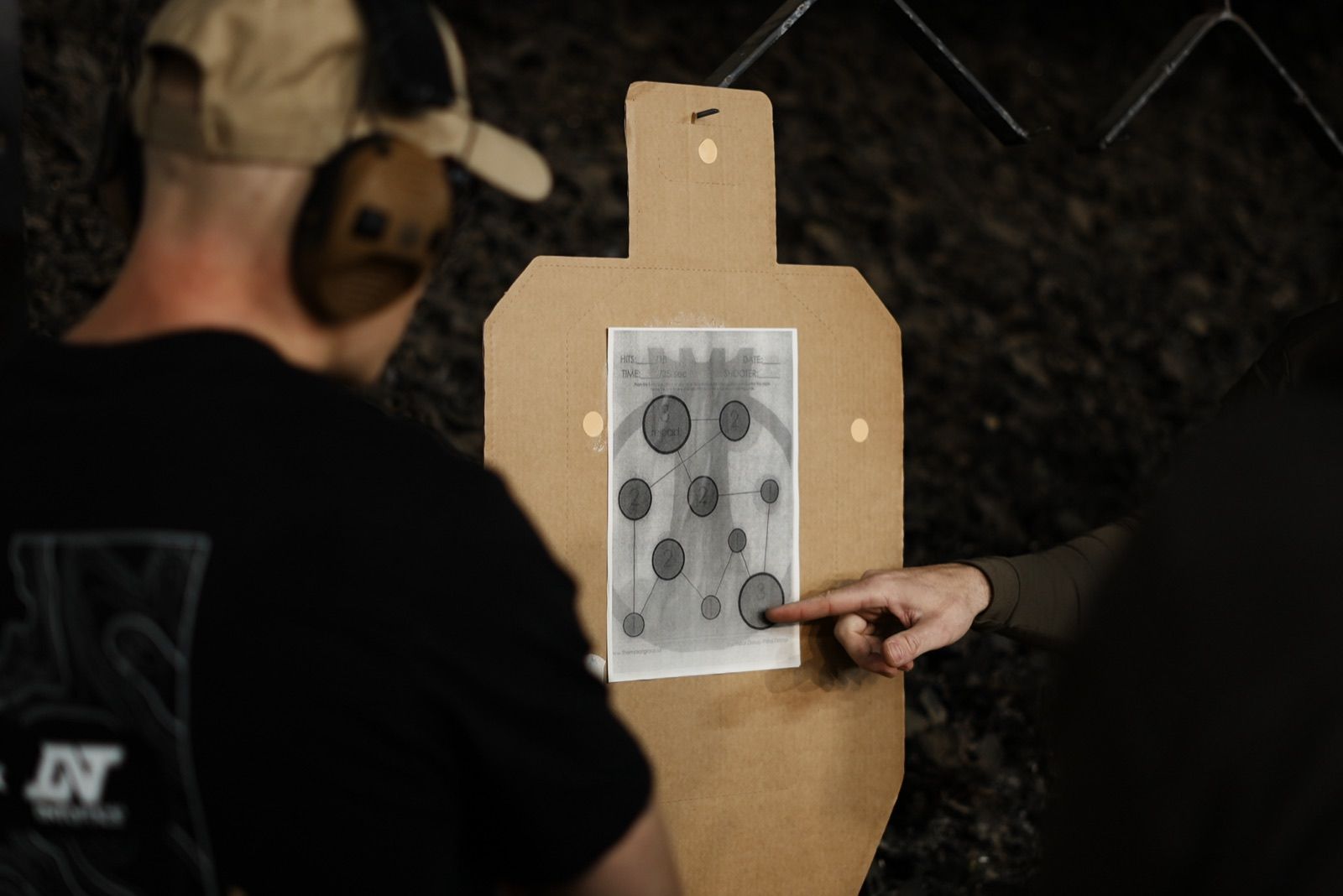 An LRT trainee reviewing a hit pattern on a paper target.